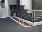 手すりに沿って歩くと頭をぶつけてしまう。危険回避のため後付けされた足元のポールも、新たな危険要因となる