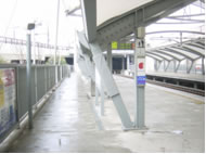 柱は垂直であるという思いこみ、グレーで目立たない色が、ぶつかり事故を生む。事後対策として柱にクッション材が巻かれているが、柱や周囲と同色であるため、注意喚起効果は期待できない