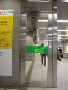 左から来た人が近道行動でぶつかる。「ガラス注意」の文字と緑色のラインで注意を喚起している