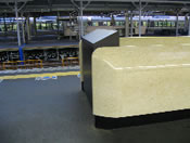 エスカレータまわりの手すり壁の天端を傾斜や曲面にしてものが置けないようにしたデザイン（事前対策）